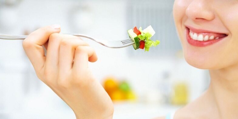 La ragazza mangia insalata di verdure, perdendo peso con la sua dieta preferita