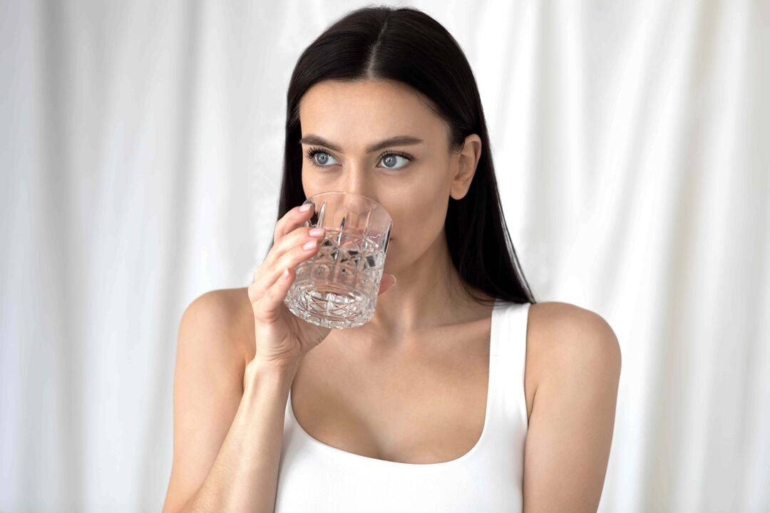 la ragazza beve acqua per perdere peso con una corretta alimentazione
